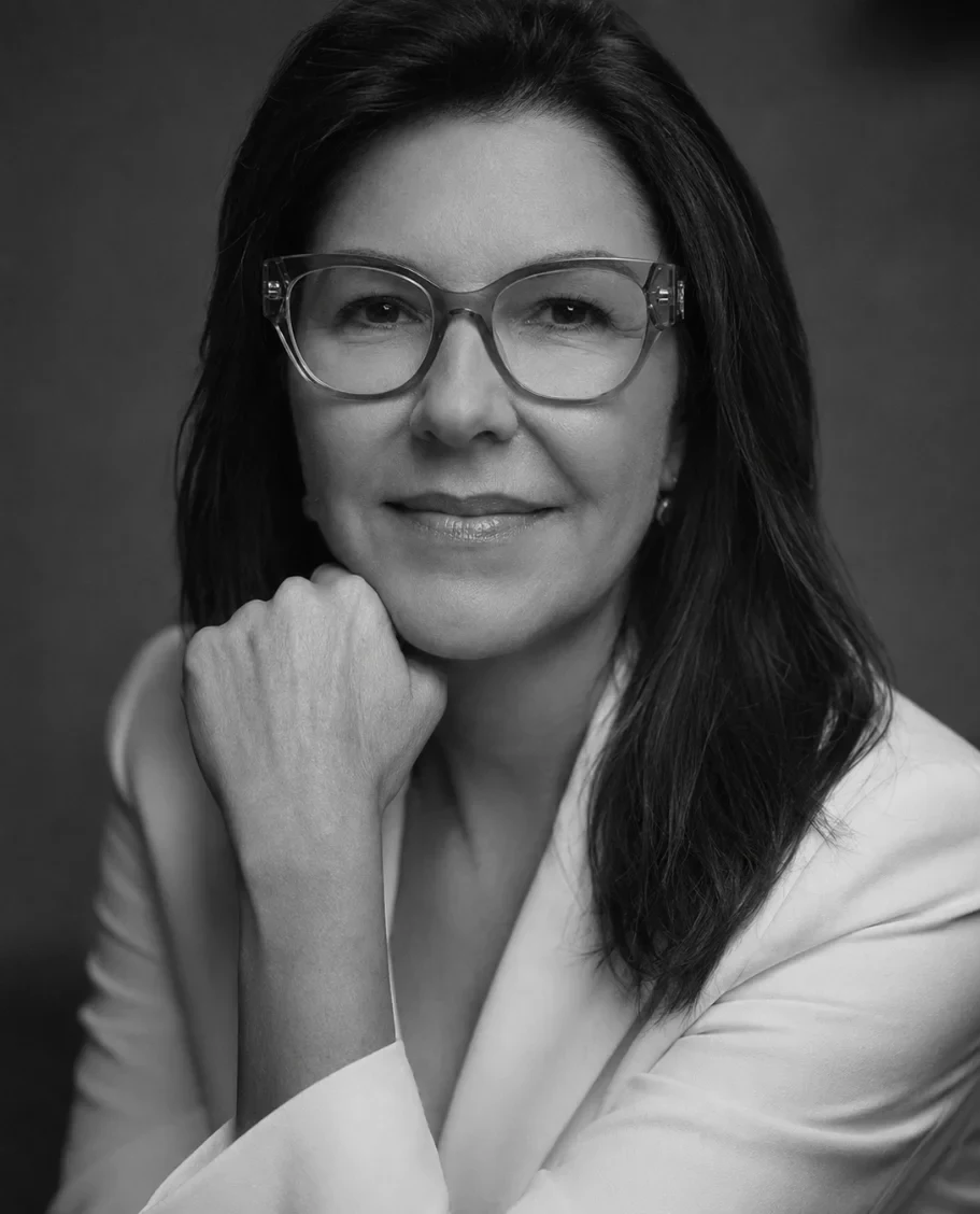 Ana Elisa sorrindo, de braços cruzados, em uma estufa de mudas.